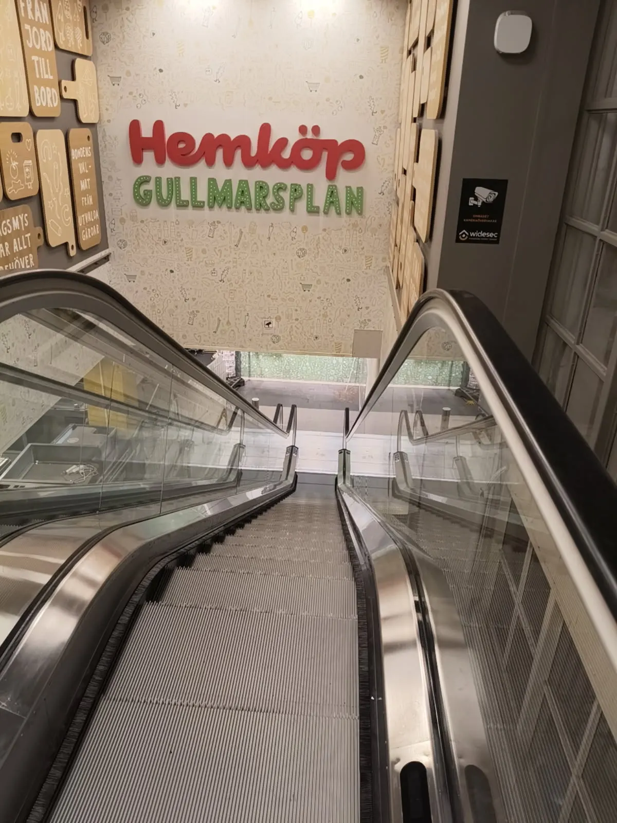 Färdig rulltrappa med butiksskylt på väggen ovanför