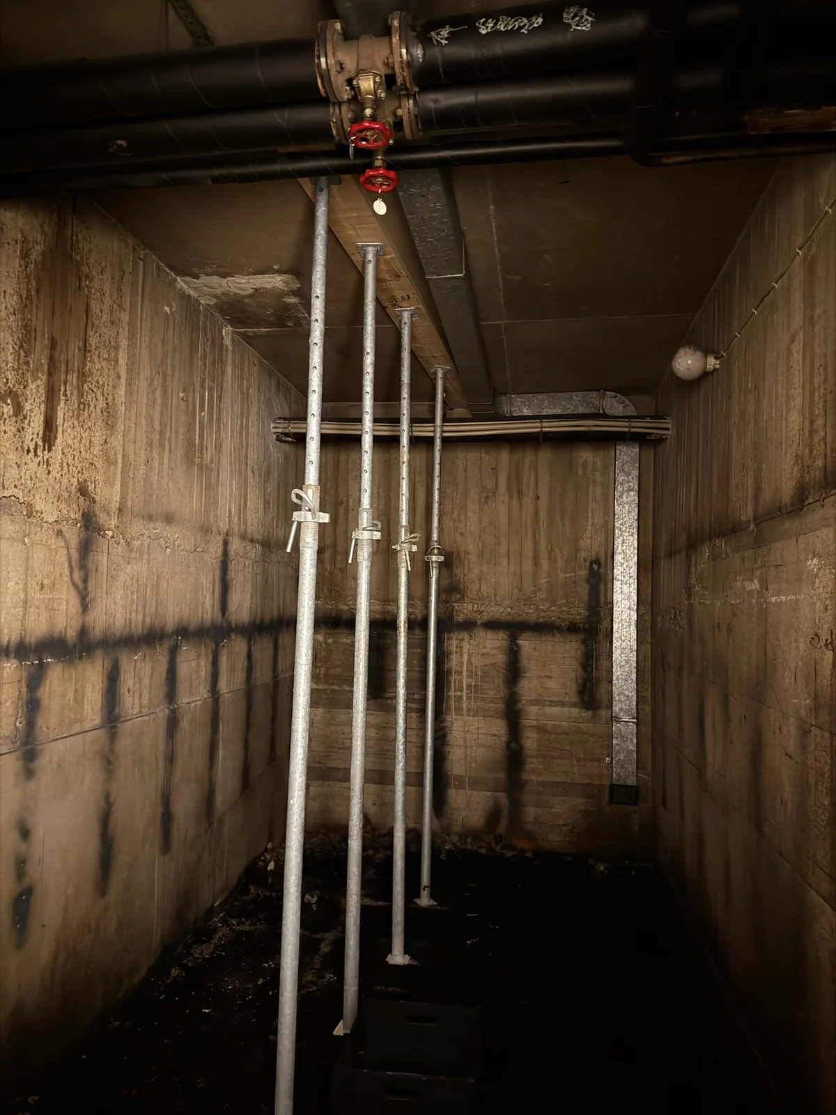 Rivet teknikrum med frilagda betongväggar och installationsrör