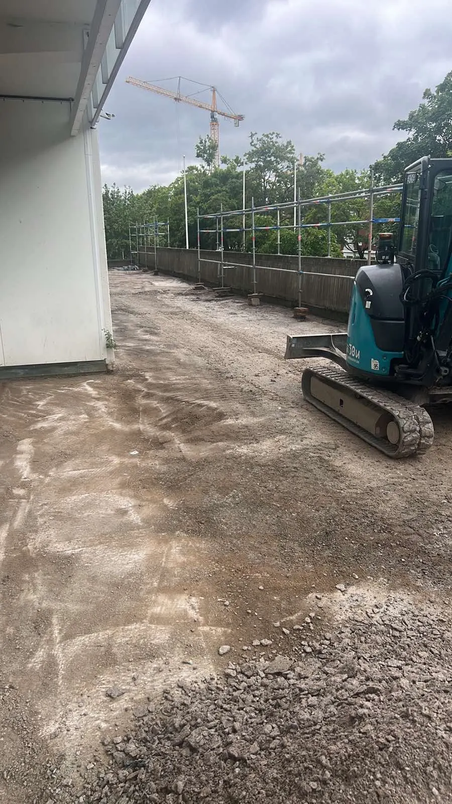Urschaktad terrassyta med grävmaskin intill fasaden