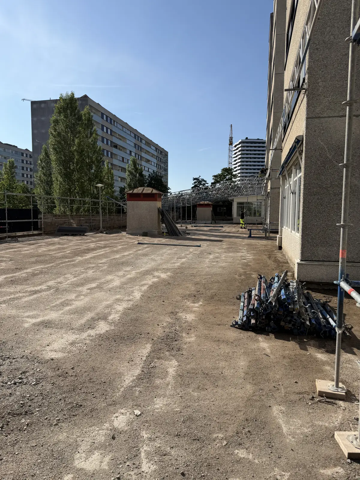 Frilagd terrassyta med ställningsmaterial längs fasaden