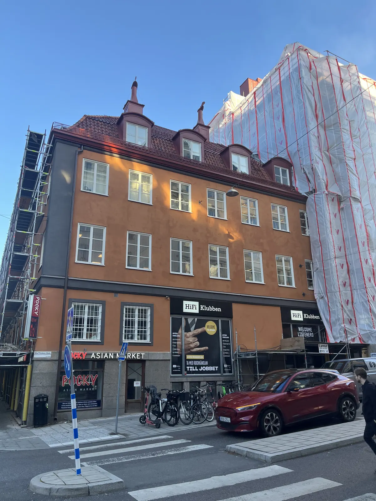 Gathörn med putsad byggnad och intilliggande fastighet under ställning